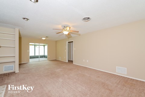 A spacious room with a ceiling fan and a window.