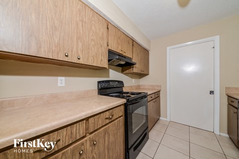 A kitchen with wooden cabinets and a black stove top oven.