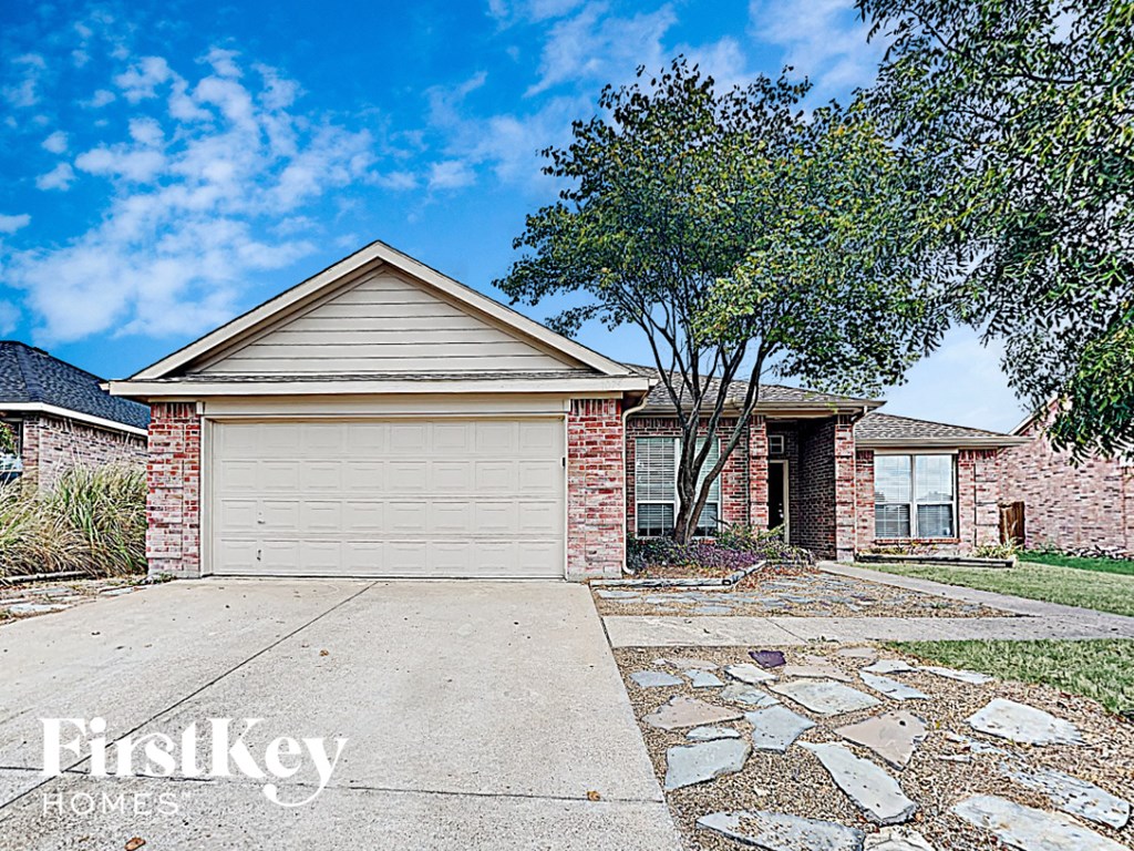 a small brick house with a white garage door