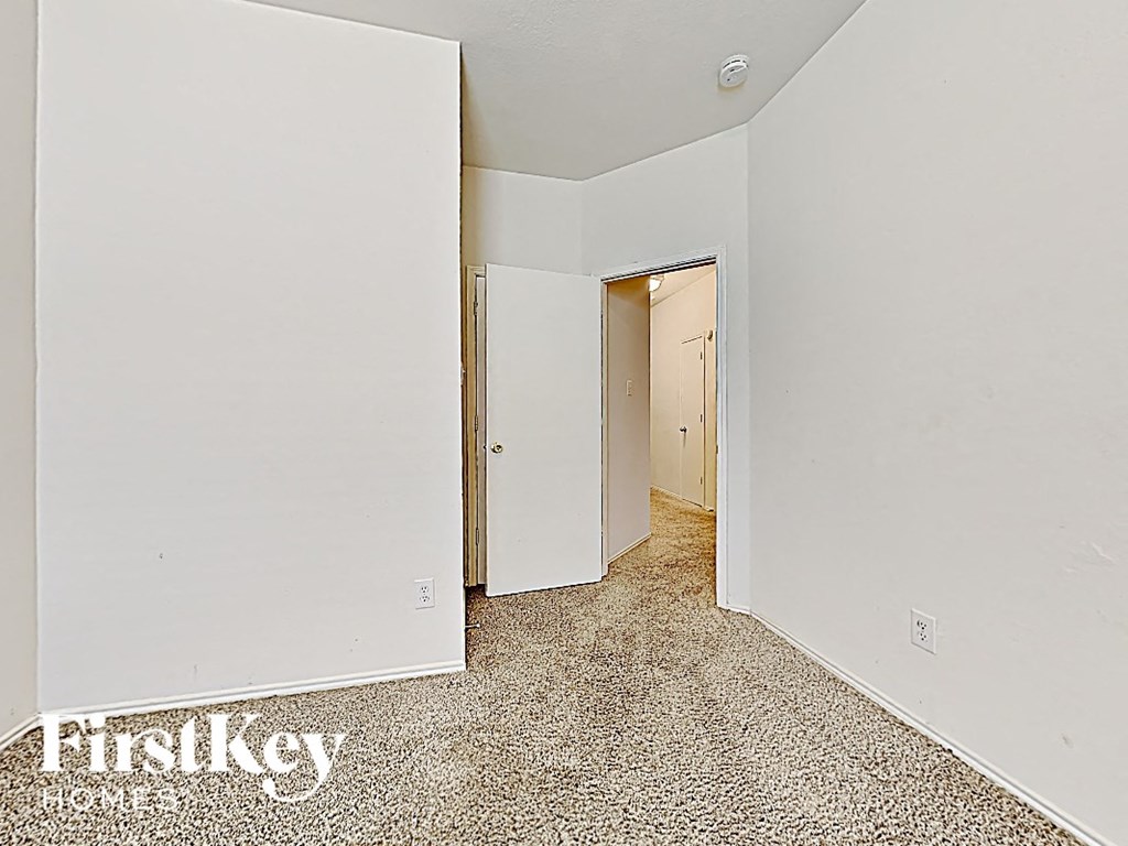 a bedroom with white walls and a carpeted floor