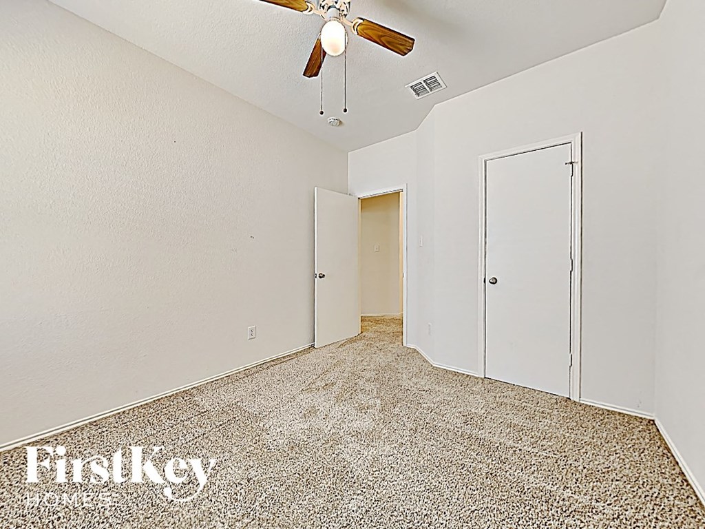 a bedroom with a ceiling fan and a closet