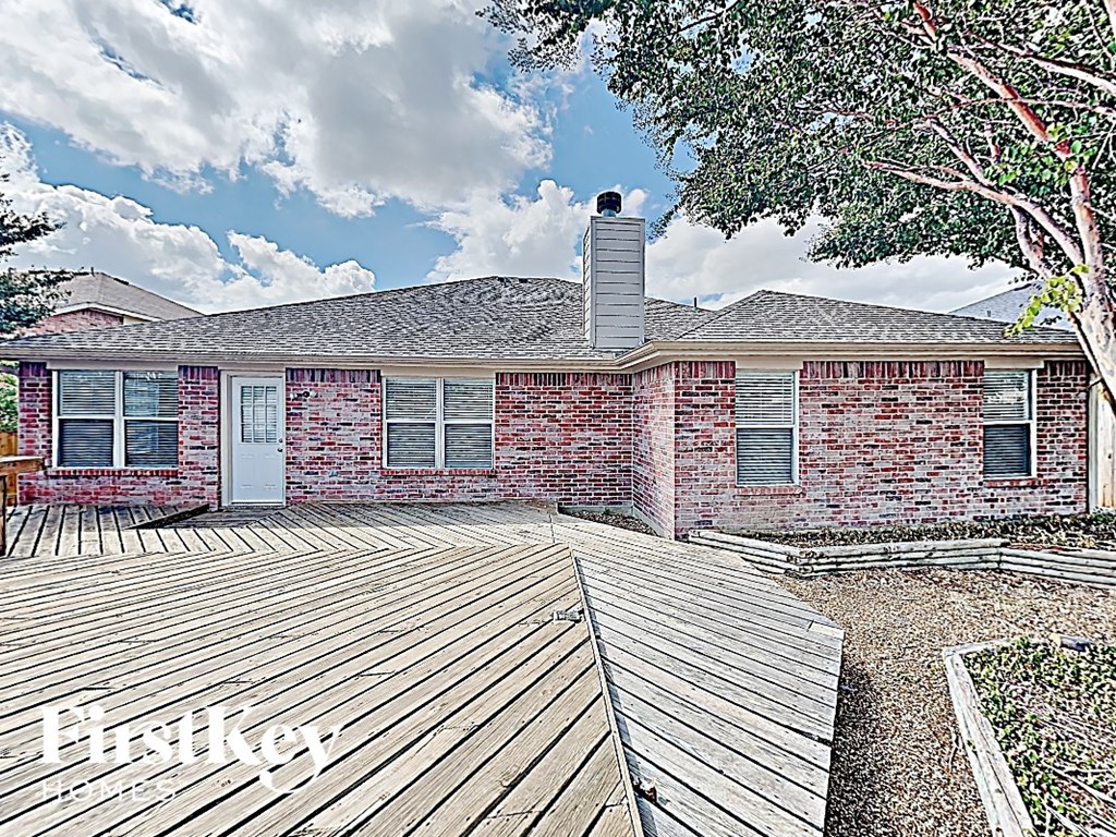 a brick house with a wooden deck in front of it