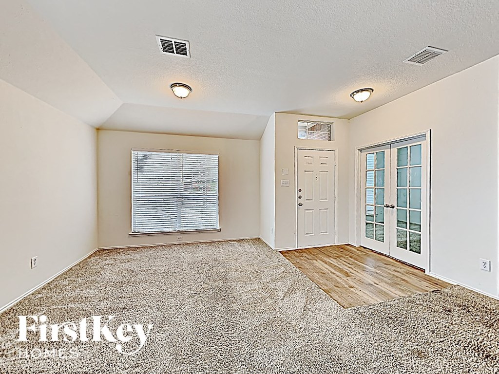 an empty living room with a door to a patio