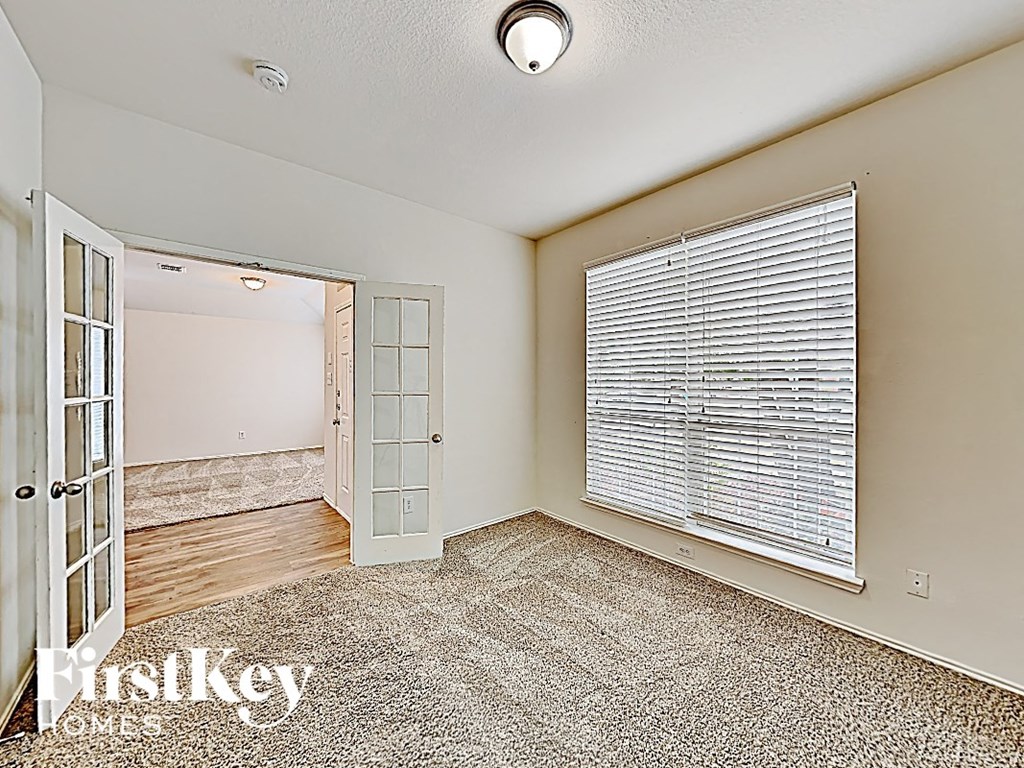 a living room with a large window and a door to a bedroom