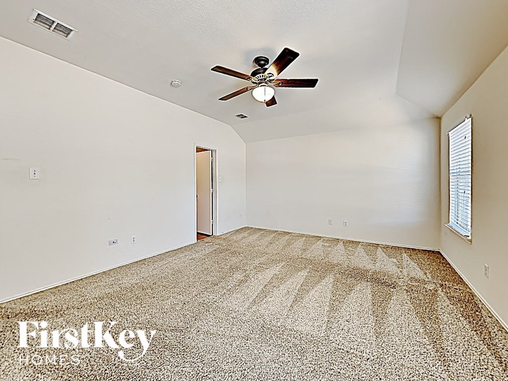 an empty room with a ceiling fan and a door to a closet