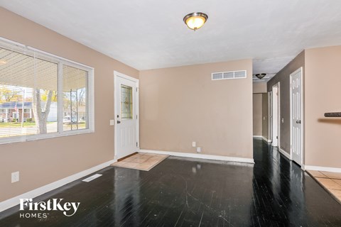 the living room and entryway of an empty house
