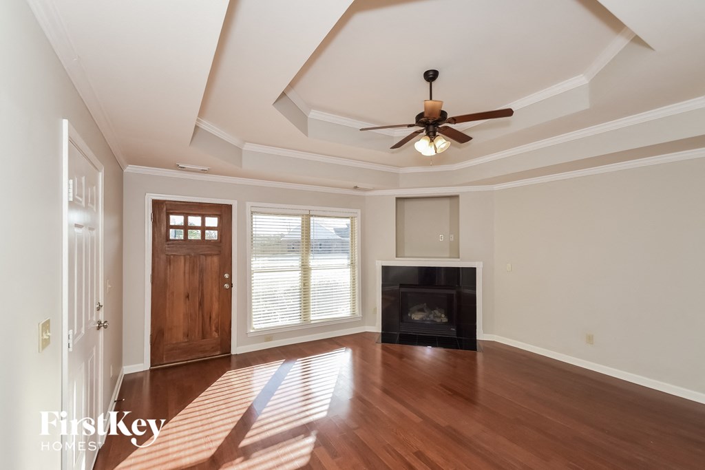 A room with a fireplace and a ceiling fan.