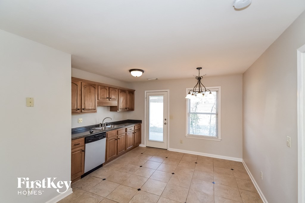 A kitchen with wooden cabinets and a tiled floor.