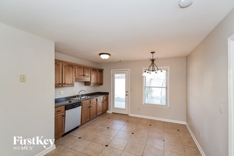A kitchen with wooden cabinets and a tiled floor.