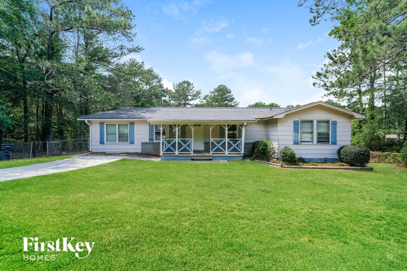 A house with a blue sky and green trees in the background.