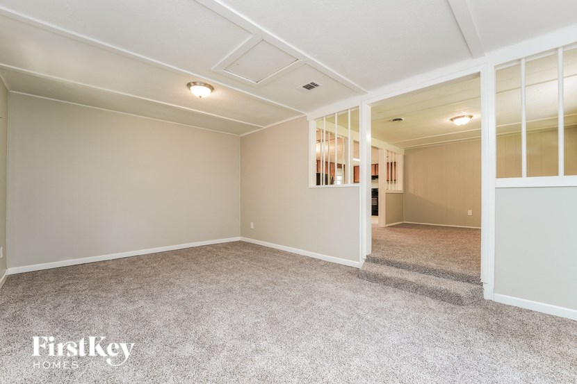 A spacious room with a carpeted floor and a white ceiling.