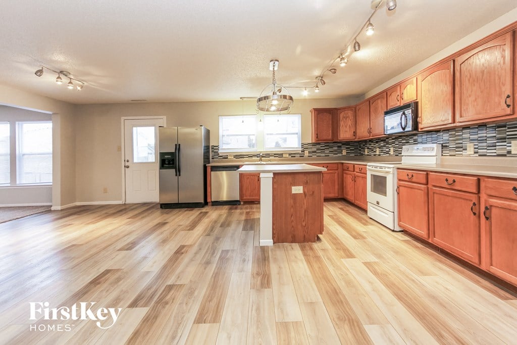 a kitchen with wood flooring and wooden cabinets