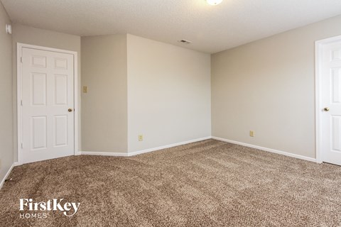 a bedroom with a carpeted floor and a white door
