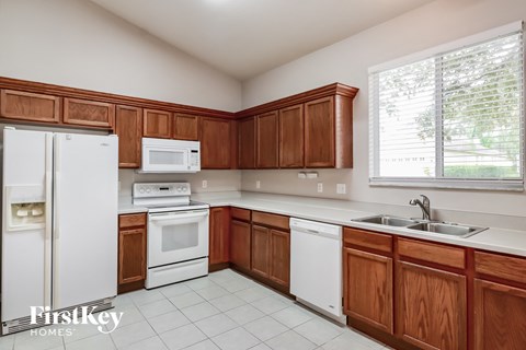 A kitchen with wooden cabinets and white appliances.