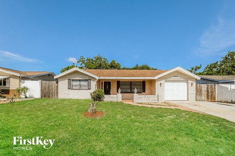 a small white house with a yard and a driveway