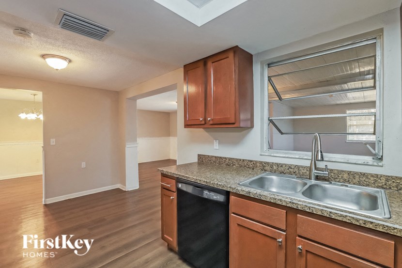 a kitchen with a sink and a window and wooden cabinets