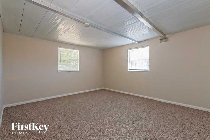 the living room of a home with carpet and two windows