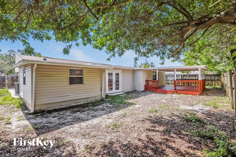 a small yellow house with a yard and a tree