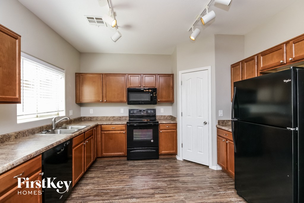 a kitchen with wooden cabinets and black appliances