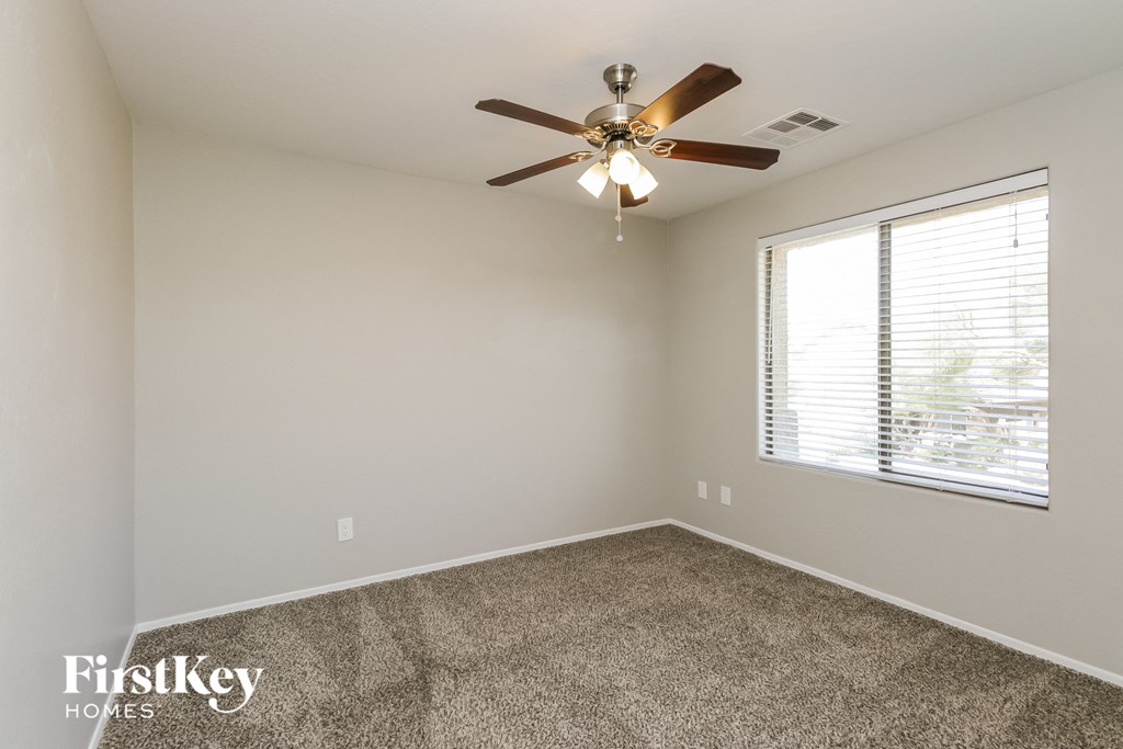 a bedroom with a ceiling fan and a window