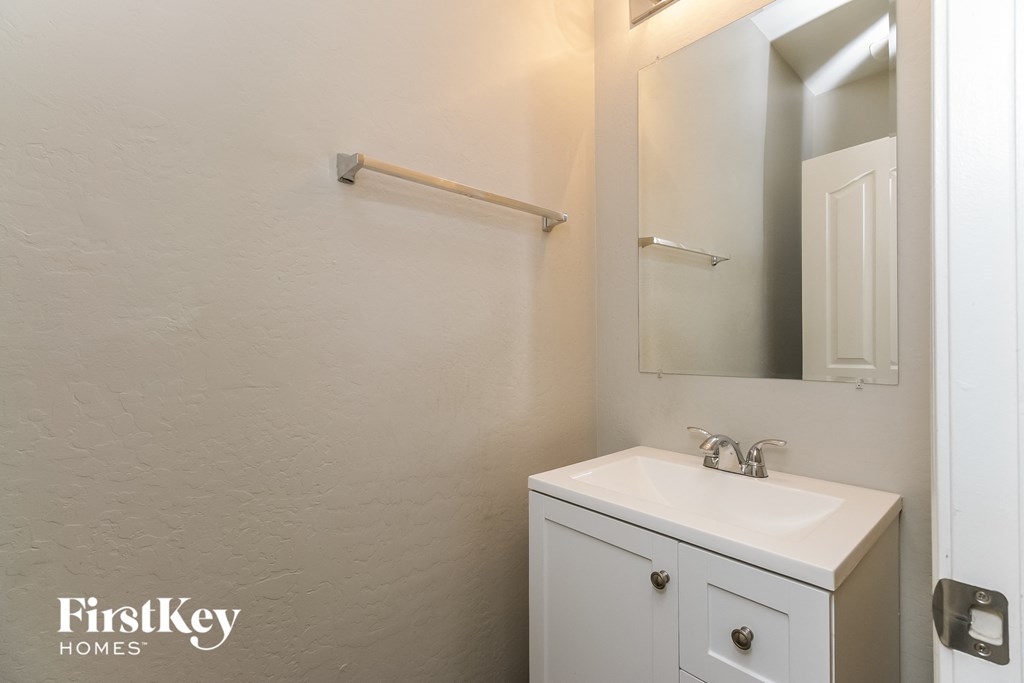 a bathroom with a sink and a mirror and a white cabinet