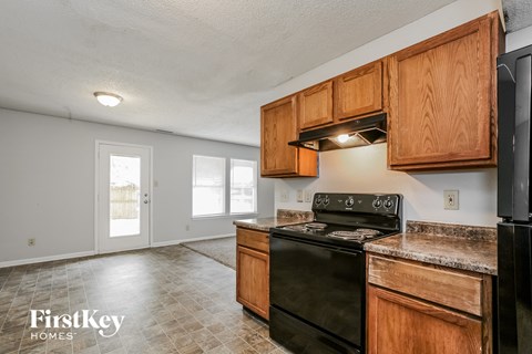 A kitchen with wooden cabinets and a black stove top oven.