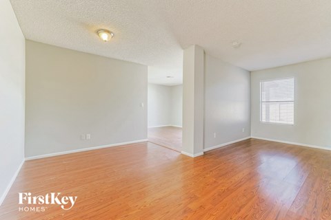the living room and dining room of an empty house with wood floors