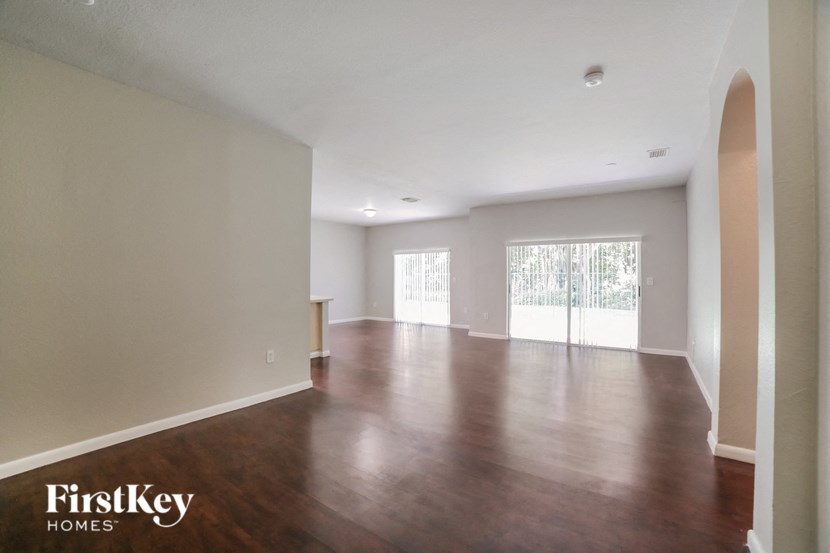an empty living room with wood floors and white walls