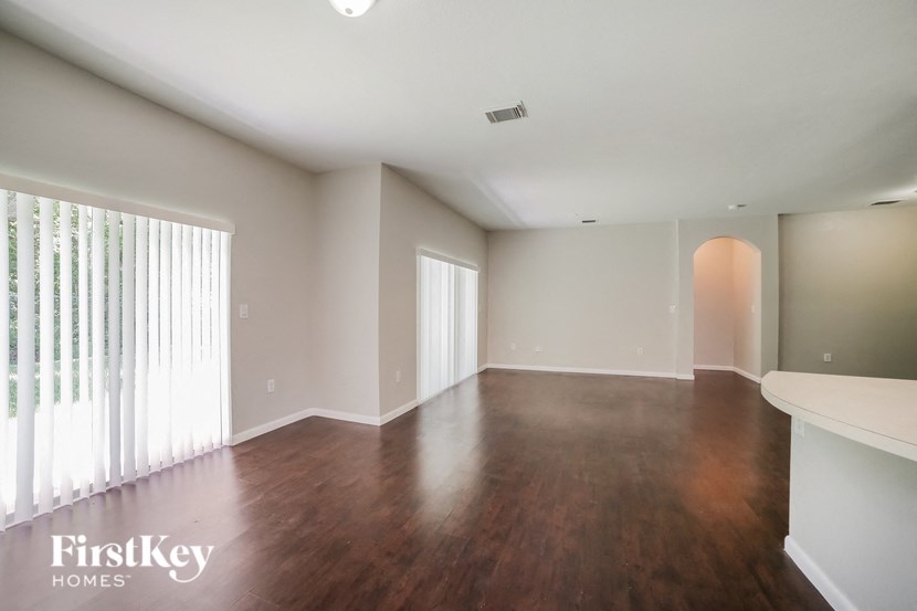 an empty living room with wood flooring and a large window