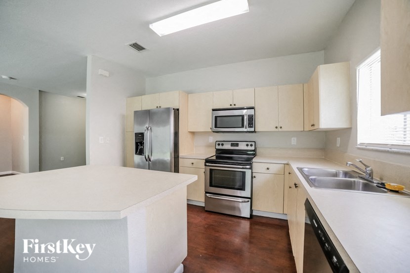a kitchen with white counter tops and stainless steel appliances