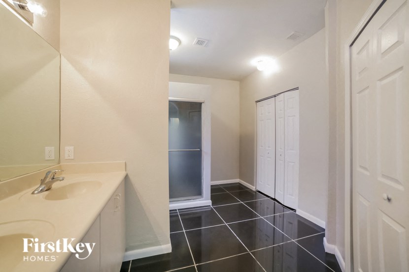 a bathroom with a sink and a mirror and a closet