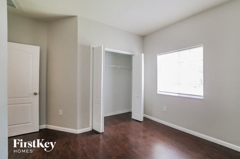 an empty room with a closet and a window