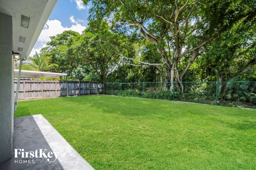 a backyard with a grass lawn and a fence
