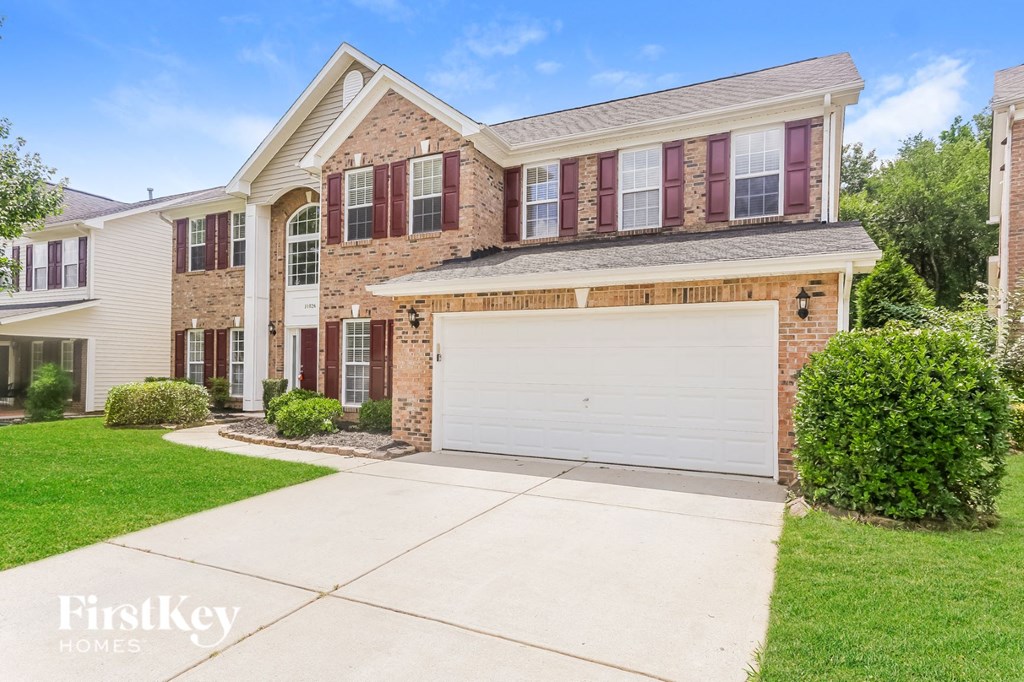a brick house with a white garage door in front of it