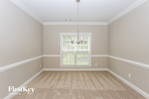 an empty dining room with carpet and a window