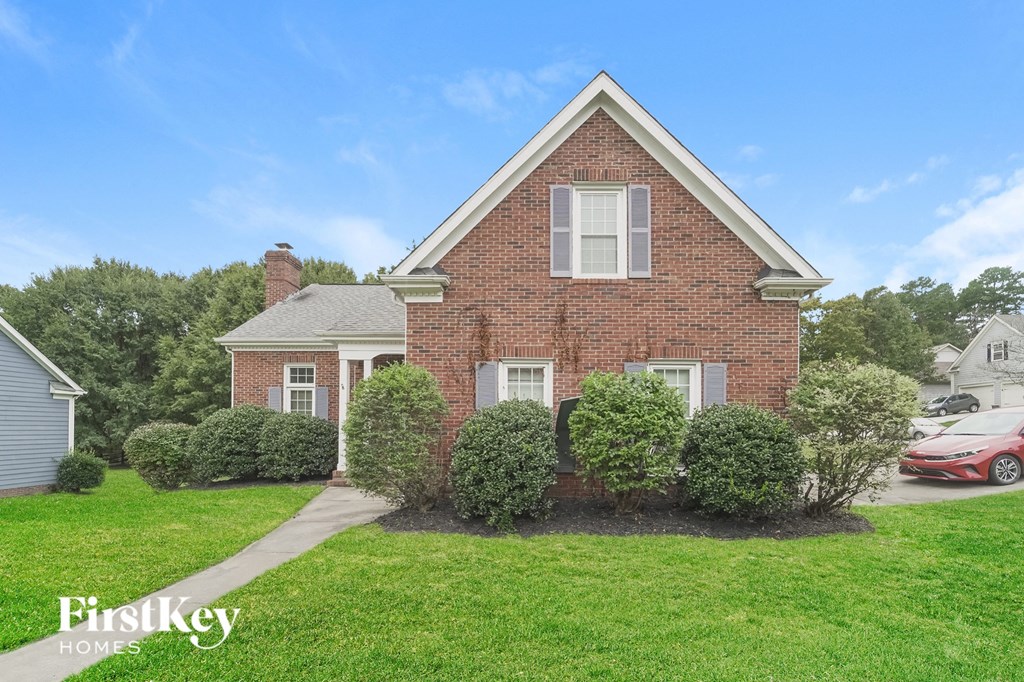 a brick house with a yard and green grass