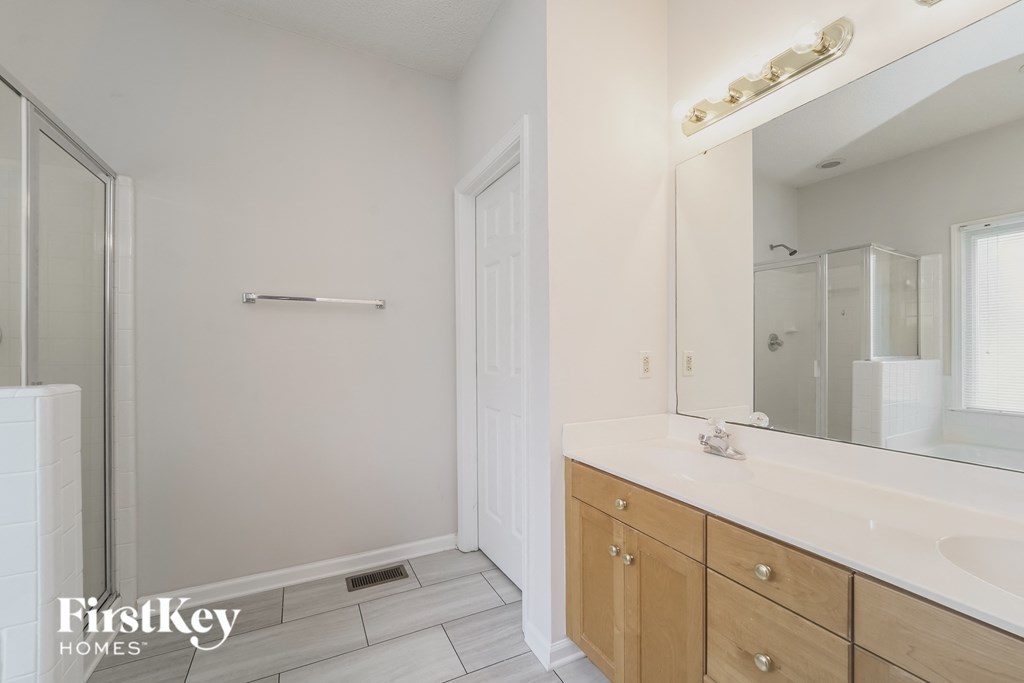 a bathroom with a large mirror and a sink and a shower