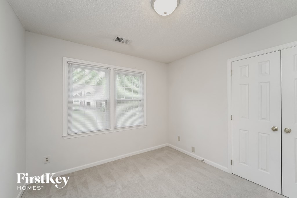 a bedroom with white walls and a white door and window