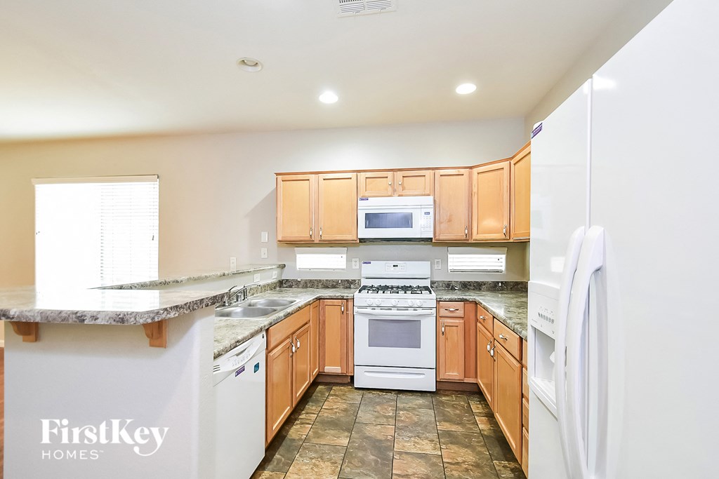 A kitchen with wooden cabinets and a marble countertop.