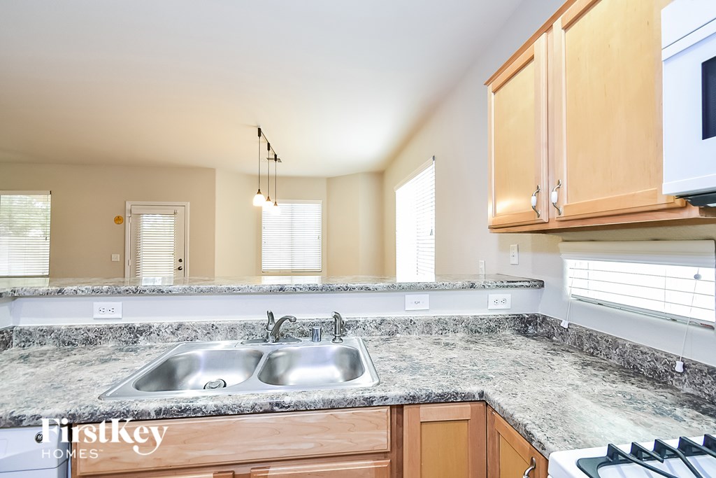 A kitchen with granite countertops and wooden cabinets.