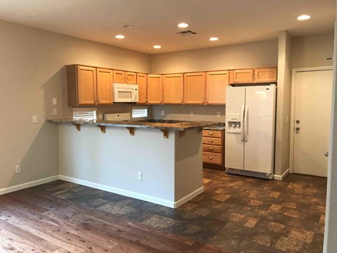 A kitchen with wooden cabinets and a white refrigerator.