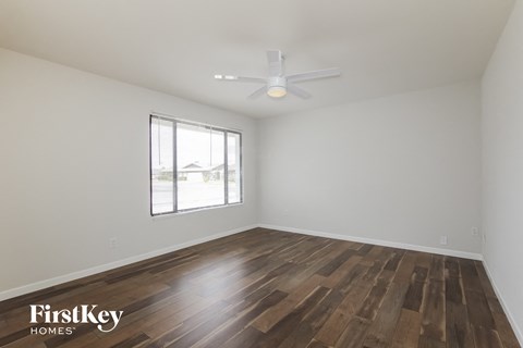 a living room with wood flooring and a ceiling fan