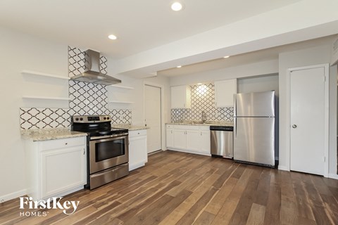 a kitchen with white cabinets and stainless steel appliances