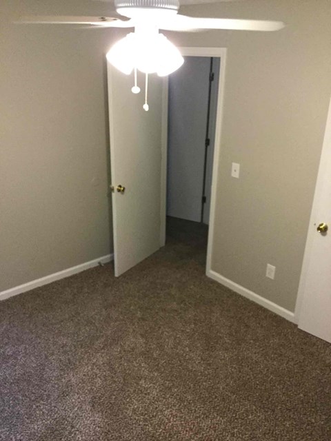 a bedroom with a carpeted floor and a door to a closet