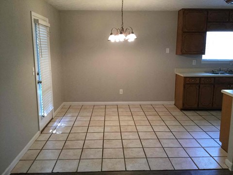 an empty kitchen and dining room with tile flooring