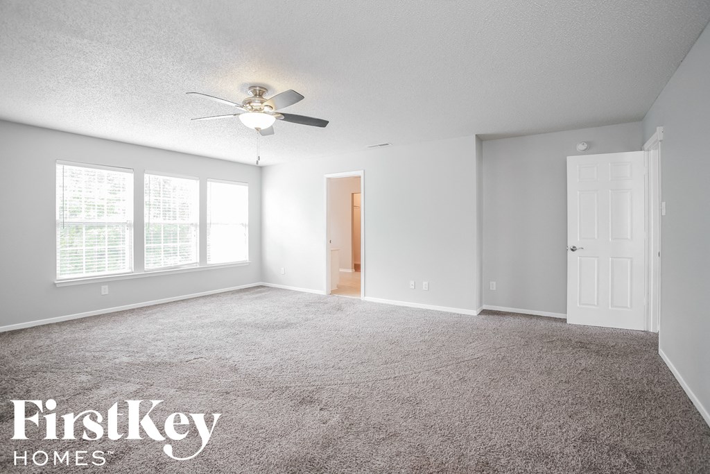 a bedroom with carpet and a ceiling fan