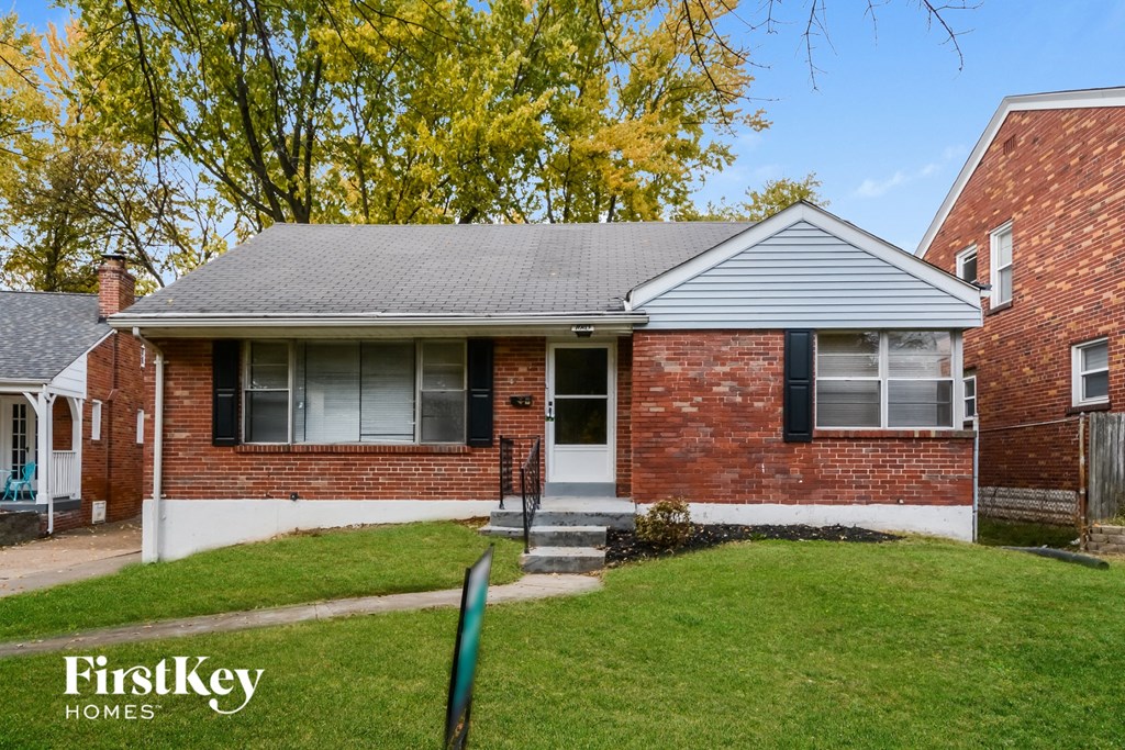 front view of a brick house with a lawn