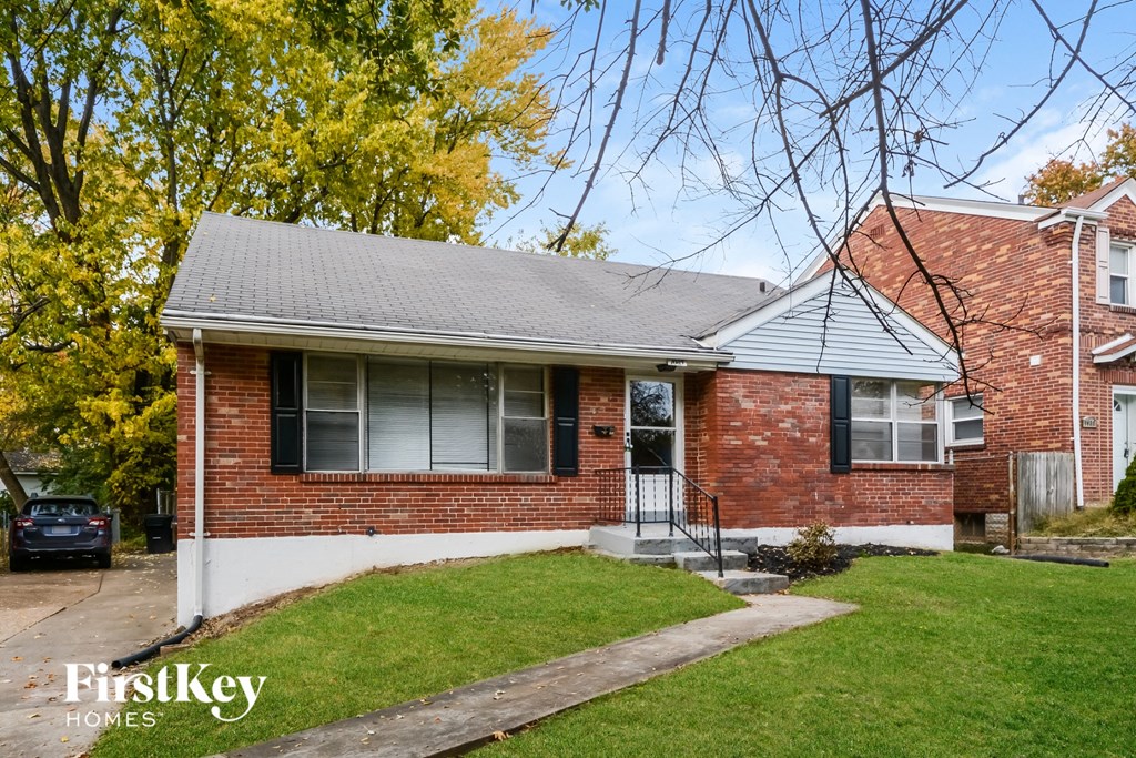 the front of a brick house with a lawn