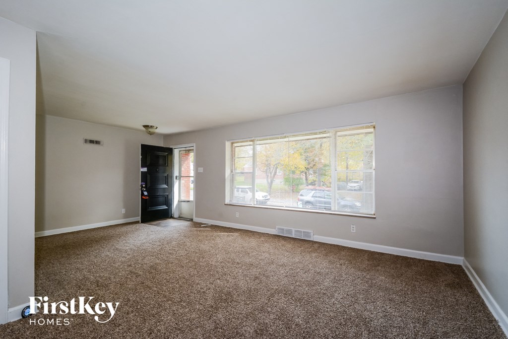 a living room with carpet and a large window