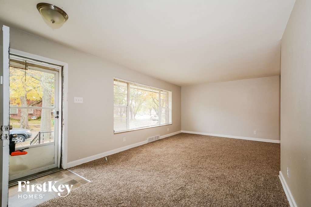 a living room with carpet and a door to a patio